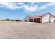 Three-car garage with metal roof and stucco exterior at 5604 S 225Th Ave, Buckeye, AZ 85326