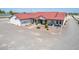 Single story home with red metal roof, large driveway, and landscaped yard at 5604 S 225Th Ave, Buckeye, AZ 85326