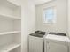 Laundry room with washer, dryer, shelving, and window at 2664 E San Miguel Dr, Casa Grande, AZ 85194