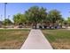 Wide paved pathway meanders through a grassy park with playground in the distance at 2664 E San Miguel Dr, Casa Grande, AZ 85194