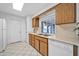 Kitchen with wood cabinets, white appliances, and tile flooring at 16828 N 108Th Ave, Sun City, AZ 85351