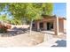 Spacious backyard with a covered patio, mature trees, and desert landscaping at 22264 N Kingston Dr, Maricopa, AZ 85138