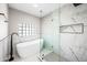 Elegant bathroom with soaking tub, walk-in shower, and marble tile at 408 E Claremont St, Phoenix, AZ 85012