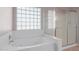 Bathroom with a bathtub, shower, and a glass block window at 4356 E Rancho Tierra Dr, Cave Creek, AZ 85331