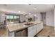 Modern kitchen with white cabinets, large island, and stainless steel appliances at 10637 W Eucalyptus Rd, Peoria, AZ 85383