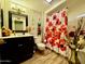 Clean bathroom with dark vanity and floral shower curtain at 17447 N 99Th Dr, Sun City, AZ 85373
