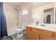 Bathroom with shower/tub combo, wood vanity, and blue shower curtain at 7959 W Waltann Ln, Peoria, AZ 85382