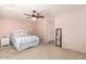Spacious bedroom with ceiling fan, double closet, and light pink walls at 7959 W Waltann Ln, Peoria, AZ 85382