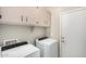 Laundry room with washer, dryer, and overhead cabinets at 22608 W Gardenia Dr, Buckeye, AZ 85326