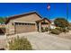 Tan house with two-car garage and landscaped yard at 22608 W Gardenia Dr, Buckeye, AZ 85326