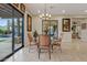 Bright dining room with glass table and chairs, offering views to the pool and mountains at 10803 W Dove Roost Rd, Queen Creek, AZ 85144