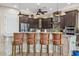 Island kitchen with dark wood cabinets and breakfast bar at 10803 W Dove Roost Rd, Queen Creek, AZ 85144