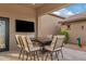 Outdoor patio dining area with fire pit and TV at 10803 W Dove Roost Rd, Queen Creek, AZ 85144