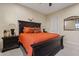 Bright bedroom with orange bedding and dark wood furniture at 10803 W Dove Roost Rd, Queen Creek, AZ 85144