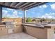 Outdoor kitchen with built-in grill and bar seating at 10803 W Dove Roost Rd, Queen Creek, AZ 85144