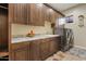 Laundry room with wood cabinets, granite countertops, and washer/dryer at 10803 W Dove Roost Rd, Queen Creek, AZ 85144
