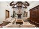 Spacious living room featuring a stone fireplace, high ceilings with exposed beams, and elegant furnishings at 20242 N 103Rd Way # 1246, Scottsdale, AZ 85255
