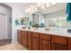 Double vanity bathroom with modern light fixtures and large mirror at 980 S 220Th Ln, Buckeye, AZ 85326