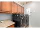 Laundry room with washer, dryer and wood cabinets at 980 S 220Th Ln, Buckeye, AZ 85326