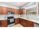 Kitchen with wooden cabinets, stainless steel appliances and a double sink at 980 S 220Th Ln, Buckeye, AZ 85326