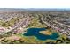 Aerial view showcasing a community with a golf course, lake, and numerous houses at 14223 W White Rock Dr, Sun City West, AZ 85375