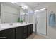 Modern bathroom with dual vanity, large mirror, and a walk-in shower at 16918 S 180Th Dr, Goodyear, AZ 85338