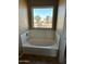 Bathroom features an oval bathtub and a large window at 9406 W Elwood St, Tolleson, AZ 85353