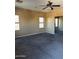 Carpeted bedroom with two windows and a ceiling fan at 9406 W Elwood St, Tolleson, AZ 85353