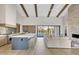 Open-concept kitchen and living area with wood beams, an island, and sliding doors to a pool at 4132 N 44Th Pl, Phoenix, AZ 85018