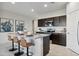 Modern kitchen with dark cabinets, granite island, and stainless steel appliances at 8422 W Mantle Way, Florence, AZ 85132