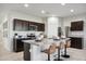 Modern kitchen with dark cabinets, granite island, and stainless steel appliances at 8422 W Mantle Way, Florence, AZ 85132