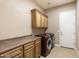 Laundry room with washer, dryer, and ample cabinetry at 2378 N 158Th Dr, Goodyear, AZ 85395