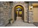 Stone arch entryway with courtyard and wrought-iron gate at 2378 N 158Th Dr, Goodyear, AZ 85395