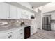 Modern kitchen with white cabinets, marble countertops and wine cooler at 10338 E San Salvador Dr, Scottsdale, AZ 85258