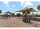 Playground with swings and play structures under shade at 38120 W Excussare Way, Maricopa, AZ 85138