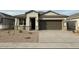 Newly built home with stone accents and a two-car garage at 38120 W Excussare Way, Maricopa, AZ 85138