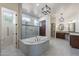 Luxurious bathroom with soaking tub, walk-in shower, and marble finishes at 3076 E La Costa Dr, Gilbert, AZ 85298