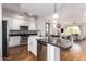Open concept kitchen with large island, stainless steel appliances, and hardwood floors at 6745 N 93Rd Ave # 1133, Glendale, AZ 85305