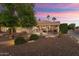 Backyard patio with seating area and fire pit, beautifully lit at sunset at 2606 N 159Th Dr, Goodyear, AZ 85395
