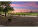 Landscaped backyard with golf course views at sunset at 2606 N 159Th Dr, Goodyear, AZ 85395