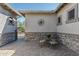 Brick paved courtyard with stone wall, wrought iron furniture, and sunburst wall art at 4126 S Last Chance Trl, Gold Canyon, AZ 85118