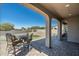 Covered patio with brick paving, seating area, and putting green view at 4126 S Last Chance Trl, Gold Canyon, AZ 85118