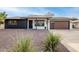 Modern home exterior with dark trim, solar panels, and a brown garage door at 9339 W Spanish Moss Ln, Sun City, AZ 85373