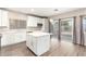 Modern kitchen with white cabinets, island, and stainless steel appliances at 20293 N 83Rd Dr, Peoria, AZ 85382