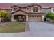 Two-story house with beige exterior, landscaped front yard, and a three-car garage at 20293 N 83Rd Dr, Peoria, AZ 85382