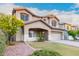 Two-story house with a beige facade, landscaped yard, and a three-car garage at 20293 N 83Rd Dr, Peoria, AZ 85382