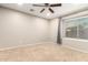Carpeted bedroom with ceiling fan and window with sunset view at 20293 N 83Rd Dr, Peoria, AZ 85382
