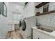 Bright laundry room with white cabinets, new washer and dryer, and stylish decor at 3923 W Fox Rd, Laveen, AZ 85339