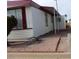 White single-wide manufactured home with red roof and covered carport at 9501 E Broadway Rd # 87, Mesa, AZ 85208