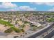 Wide aerial view of a suburban neighborhood with houses and a golf course at 19562 N Wikieup Ct, Surprise, AZ 85374